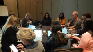 Books stacked with a laptop and smartphone for selling online.