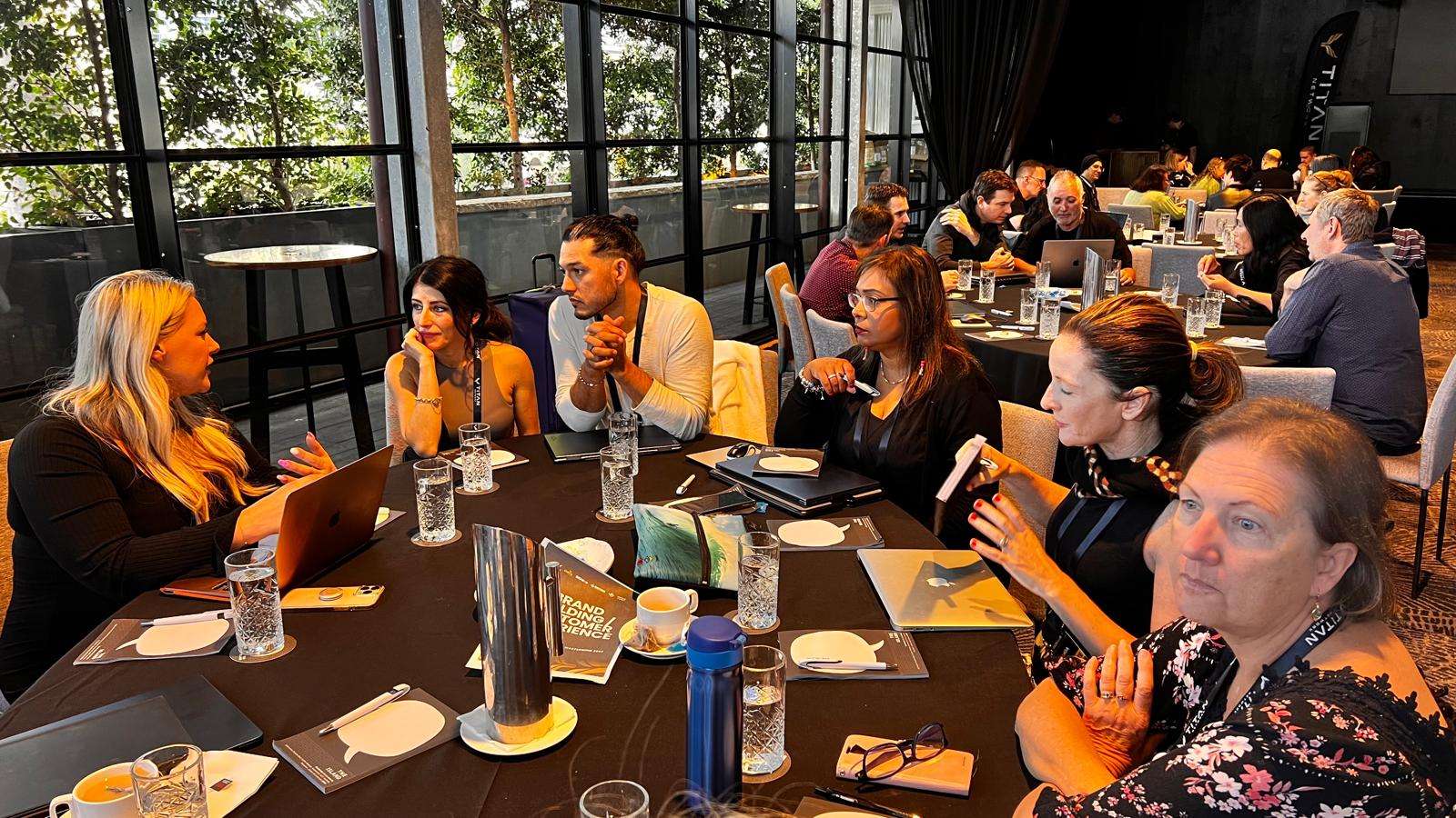 Professional coach guiding a client through goal setting in a modern office with charts and laptop on the desk.